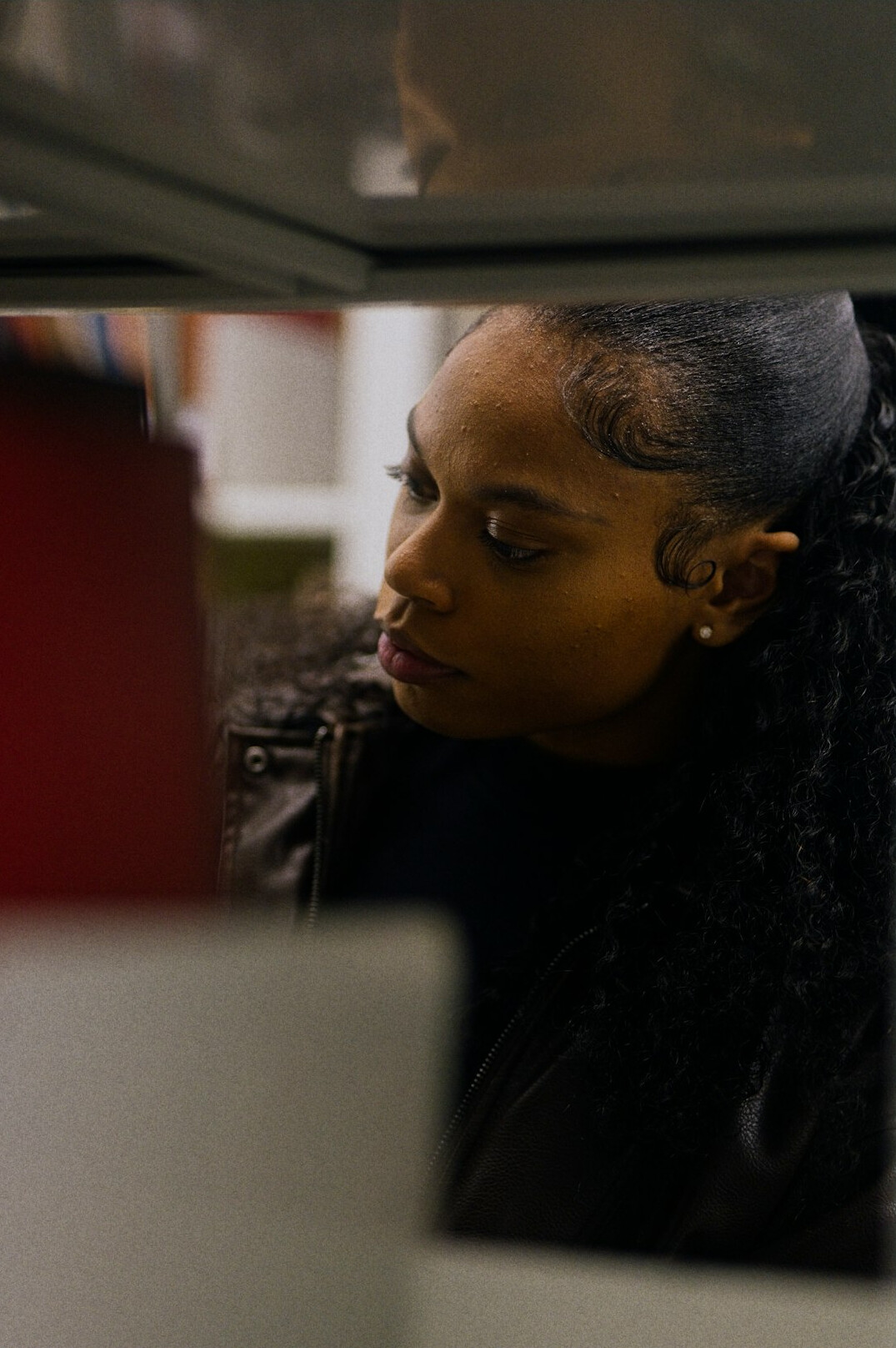 Black woman camera operator looking through a professional broadcast camera viewfinder
